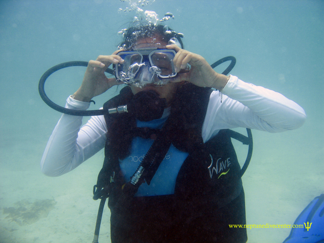 Girl clearing mask underwater